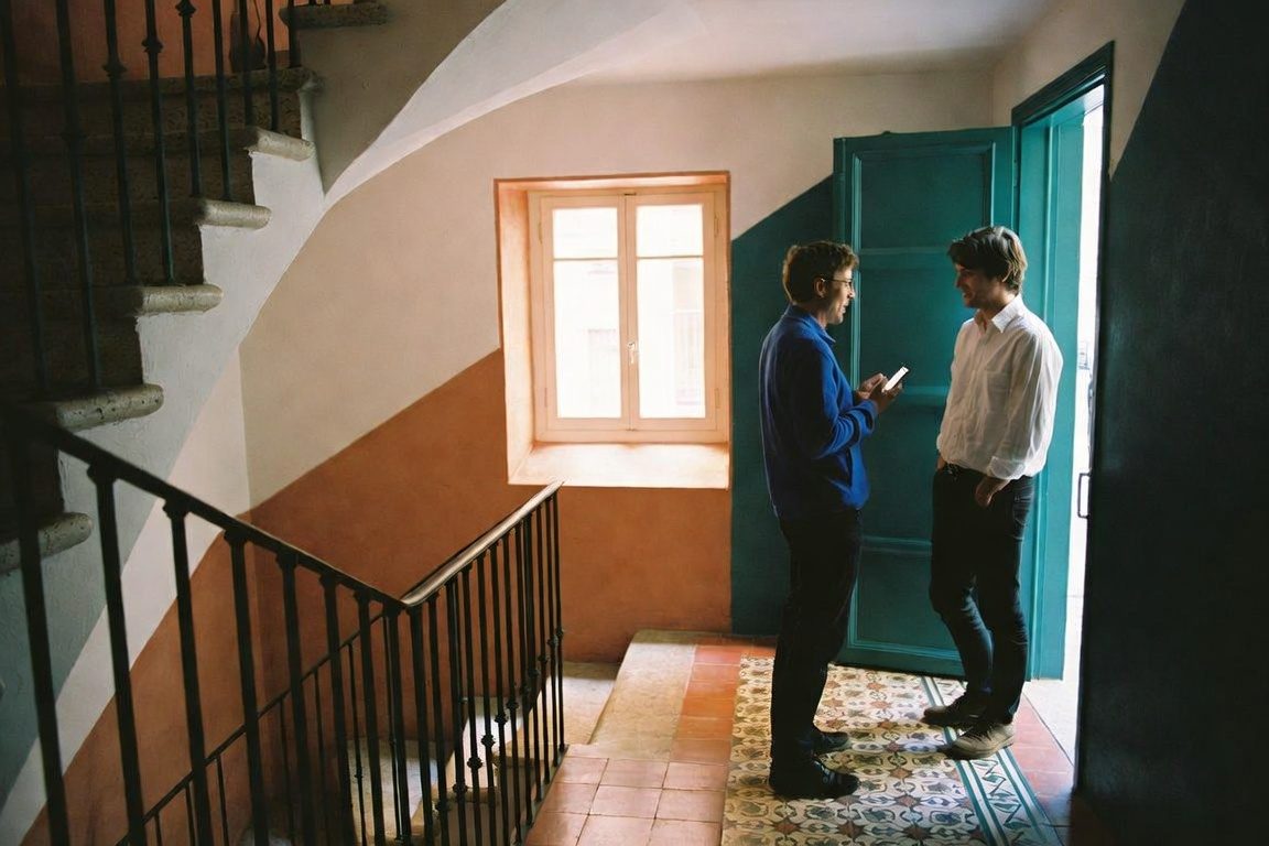 Dos veïns parlant a la porta de l'escala